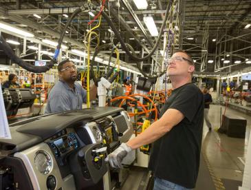 Auto workers inside a plant.